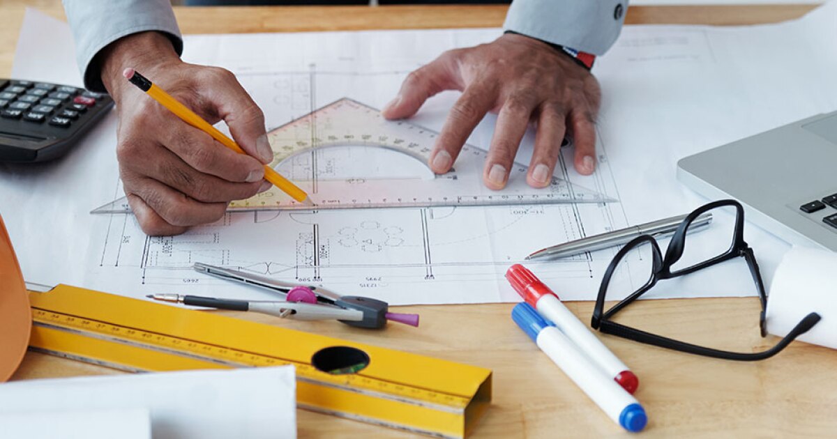 An engineer writing measurements on a piece of paper.