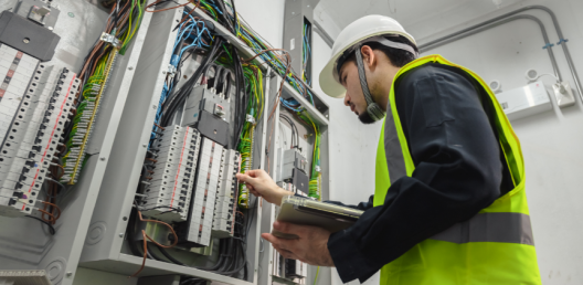 man in hard hat and green vest working on wires