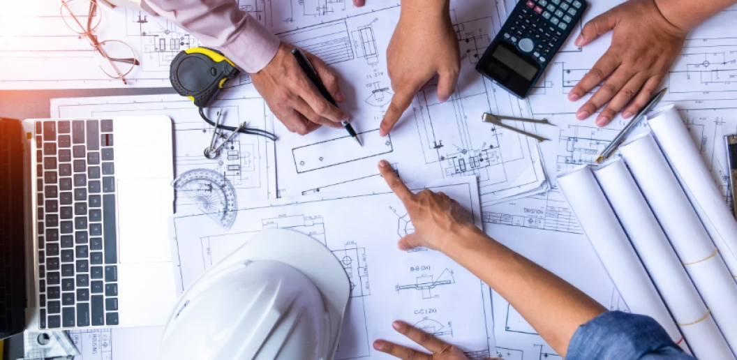 group making plans around blueprints