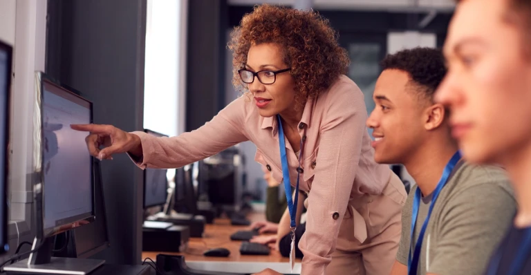 Black female professor facilitating a computer class and assisting students at their stations