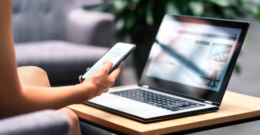 Female educator sitting at a workspace, surrounded by books and her laptop, reviewing documents 